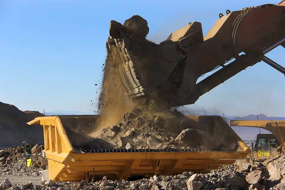 A Cat excavator loading a GRT-lined haul truck at a mine